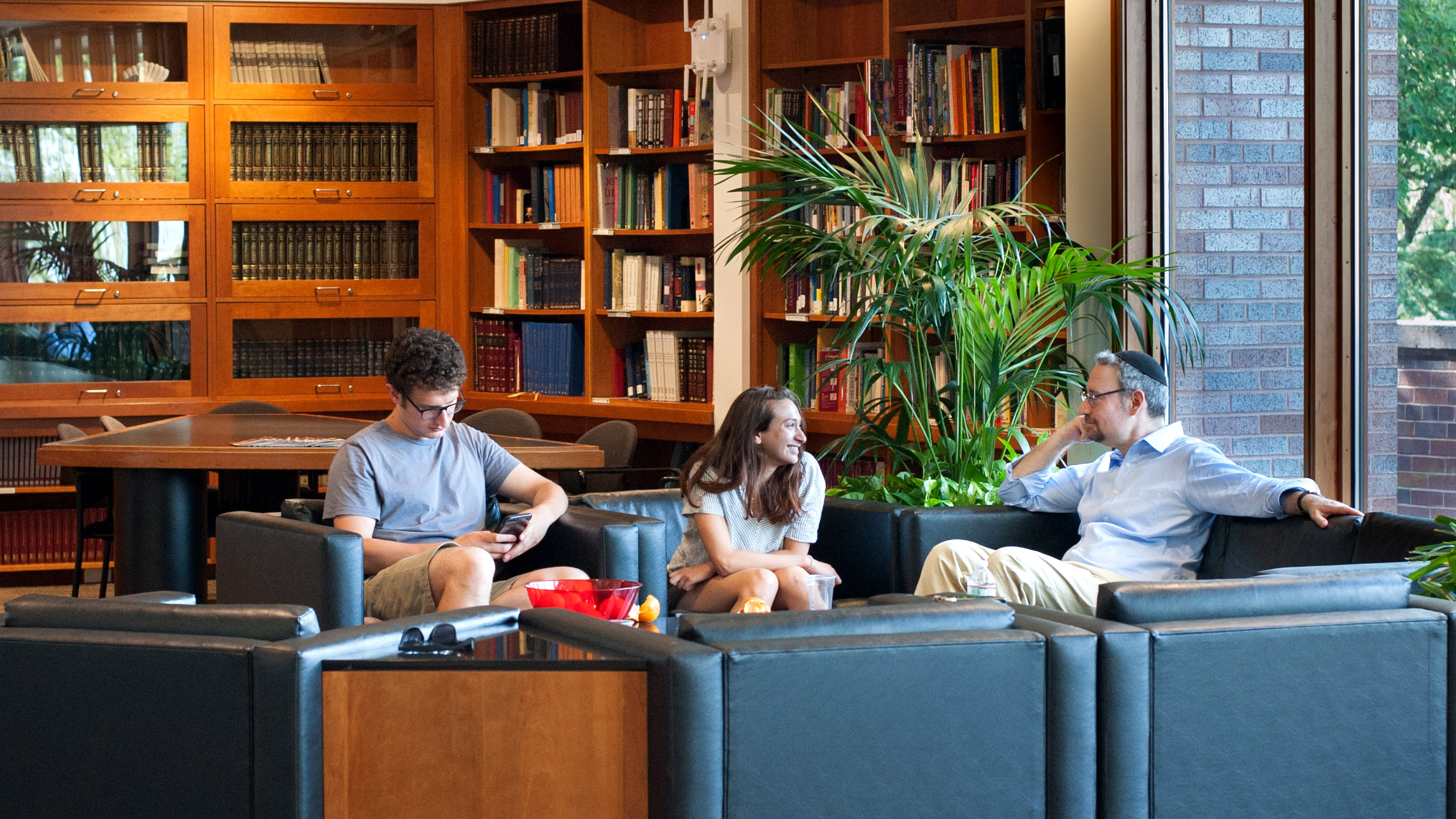 Students sit near library with Rabbi Brawer